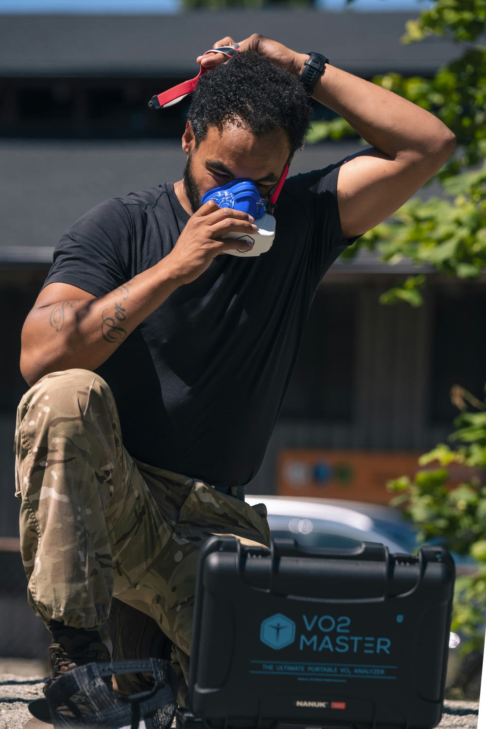 a man sitting on the ground drinking from a cup