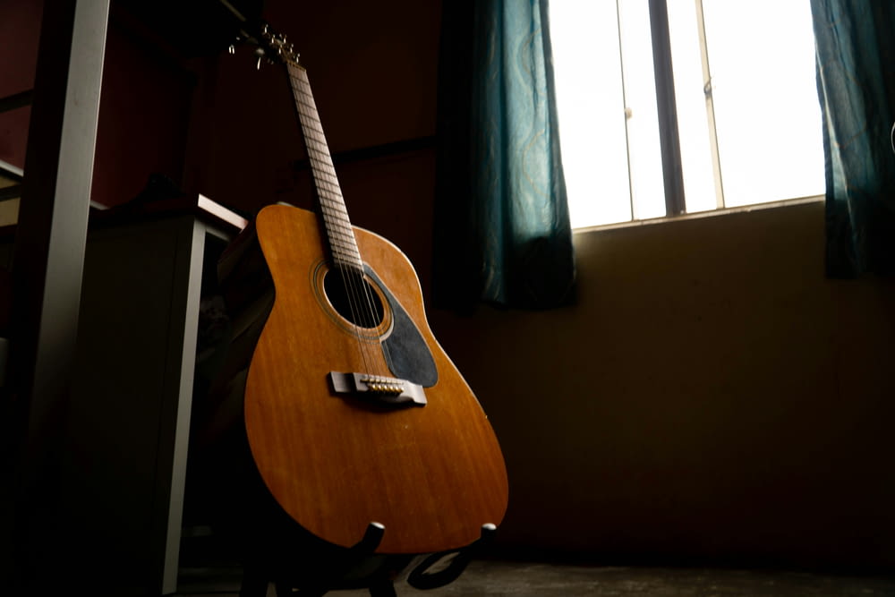 a guitar sitting in front of a window