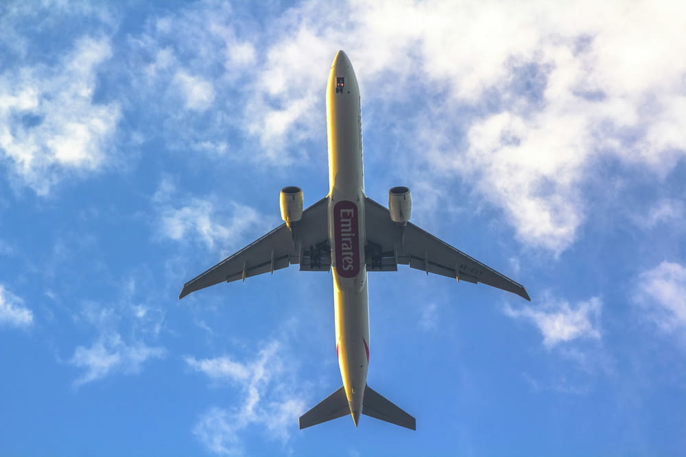 a large jetliner flying through a blue cloudy sky