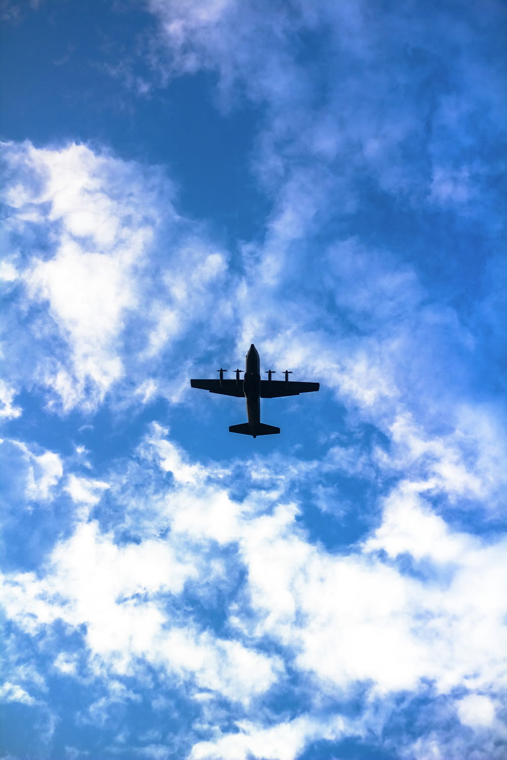 an airplane is flying through a cloudy blue sky