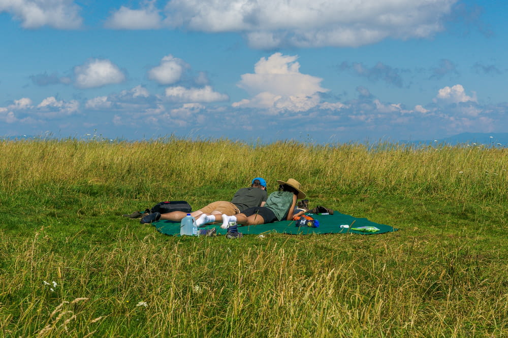 a man laying on a blanket in a field