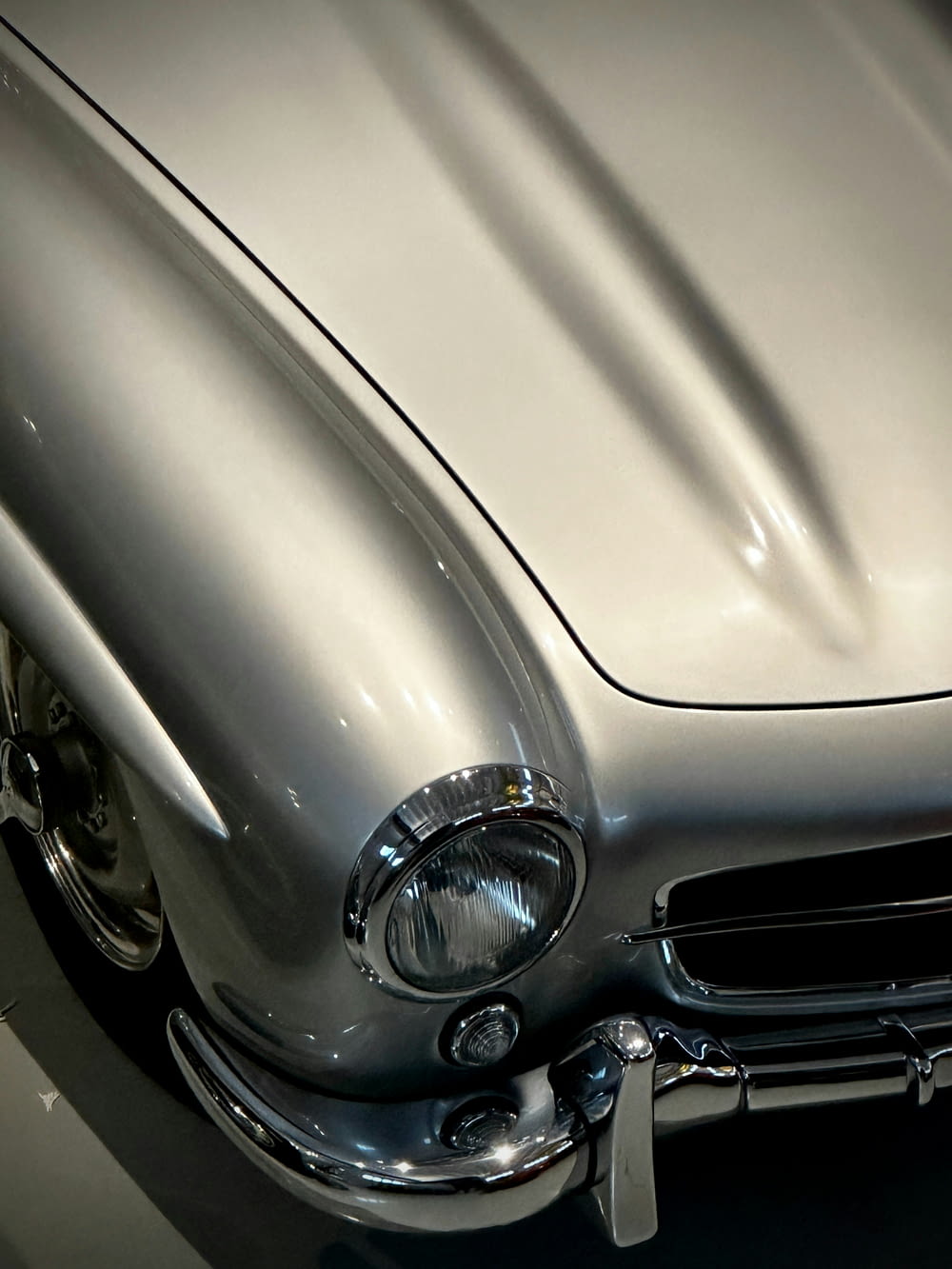 a silver classic car parked in a garage