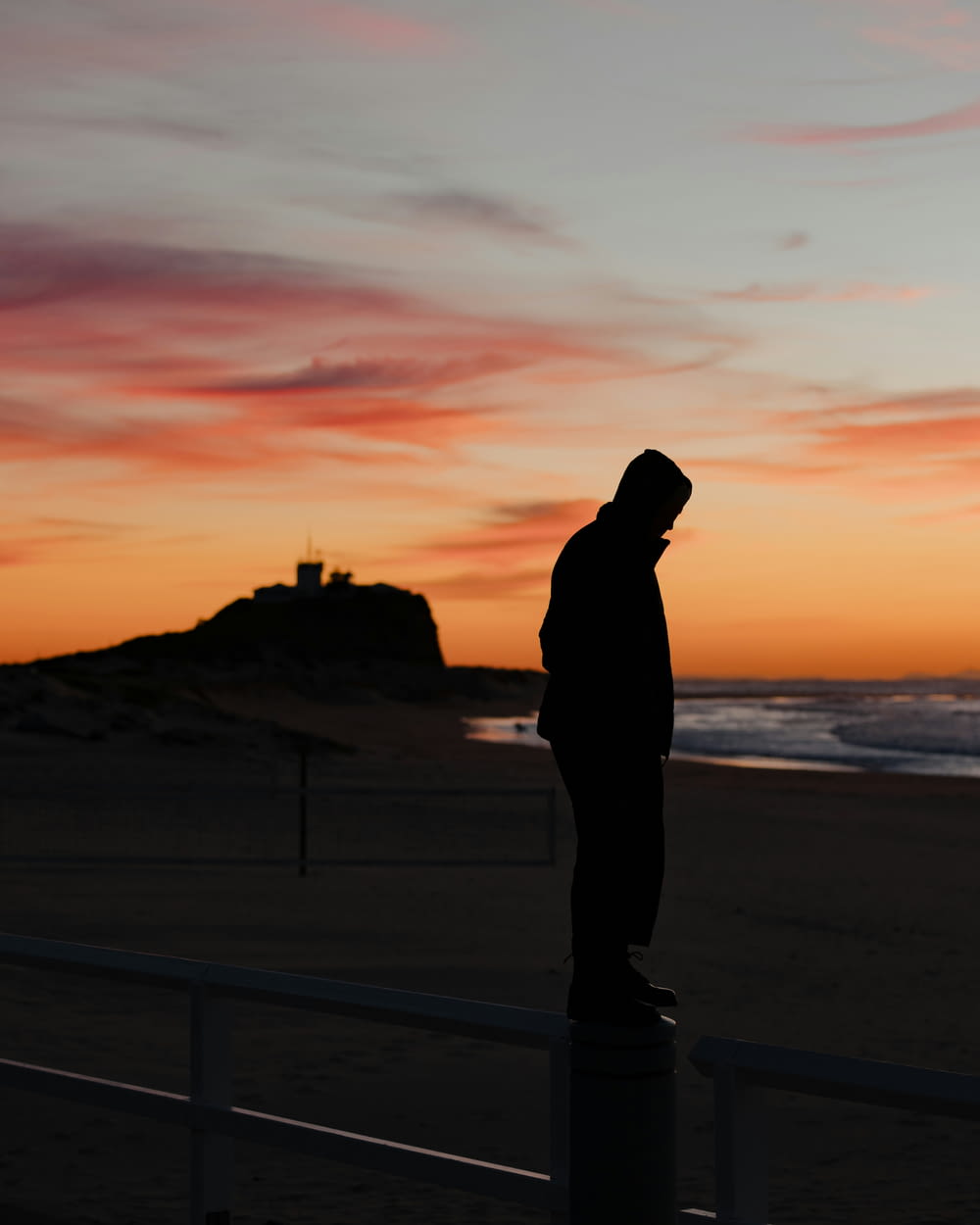 a person standing on a beach at sunset
