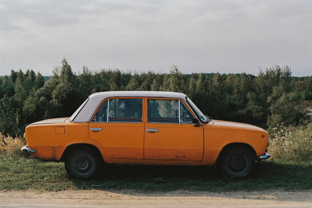 an orange car parked on the side of the road