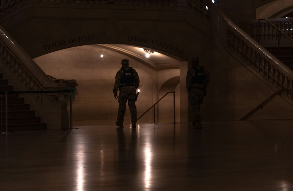two police officers standing in a dimly lit hallway