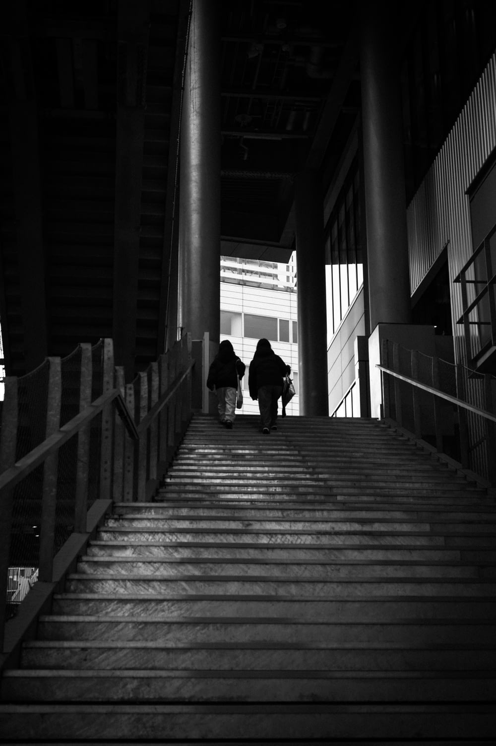 a couple of people walking down a set of stairs