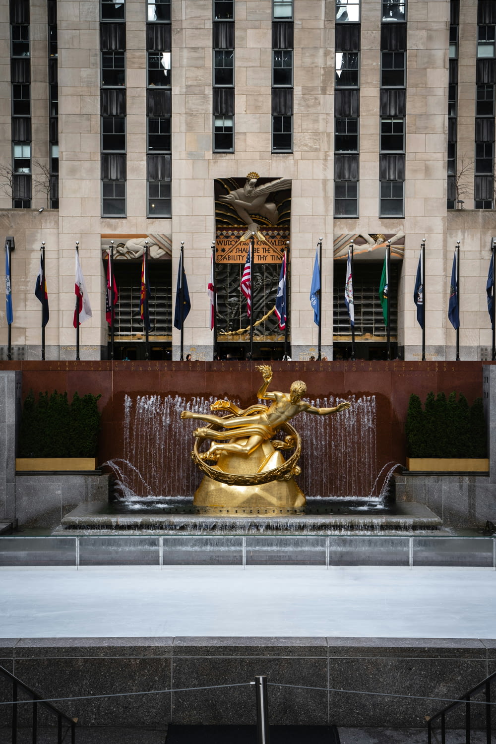 a fountain in front of a building with flags in the background