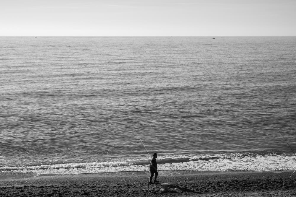 海辺の浜辺に立つ男