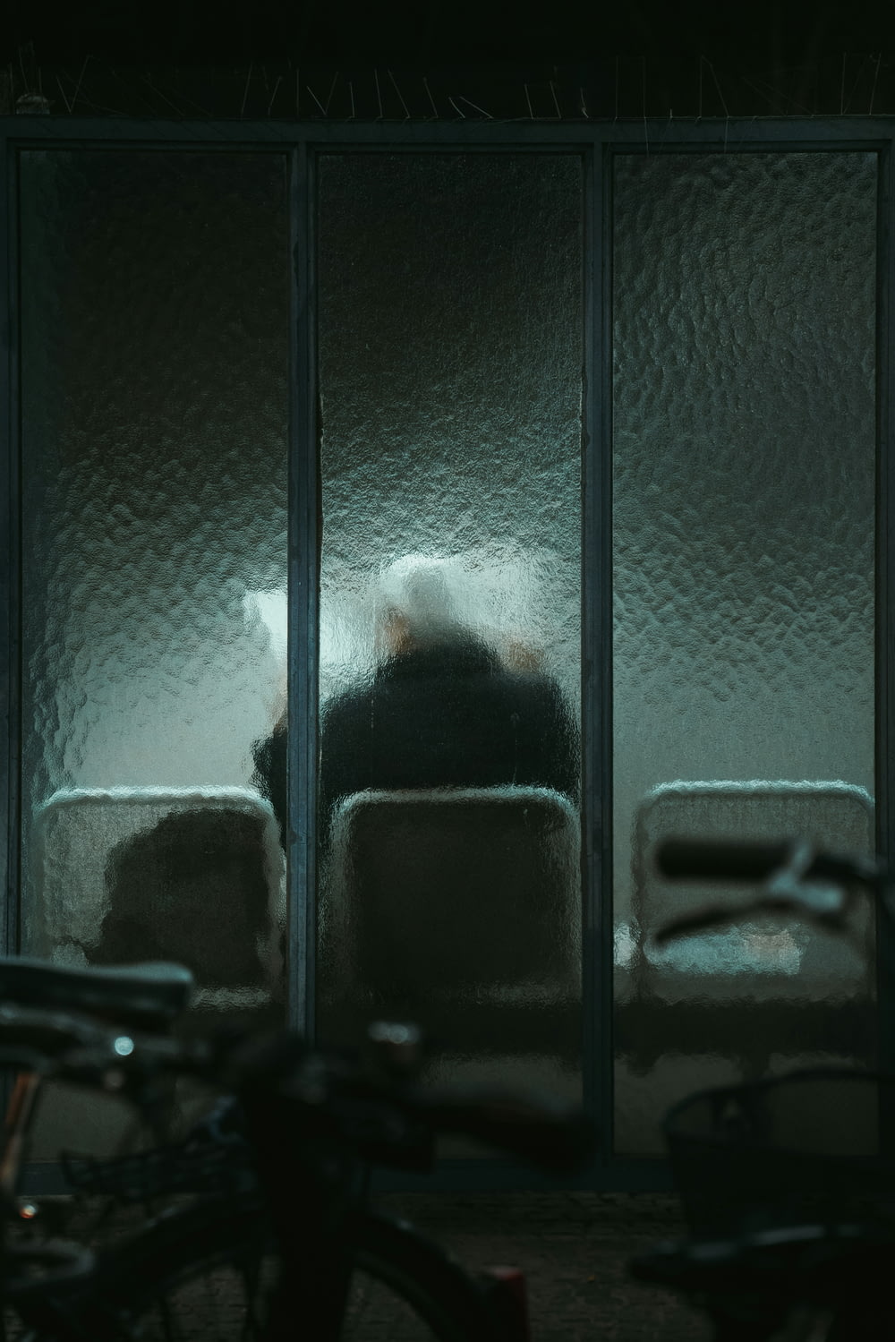 a person sitting in a chair in front of a window