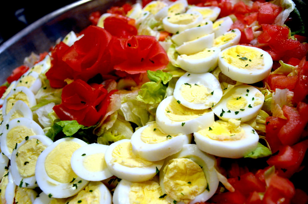 a salad with hard boiled eggs, tomatoes and lettuce