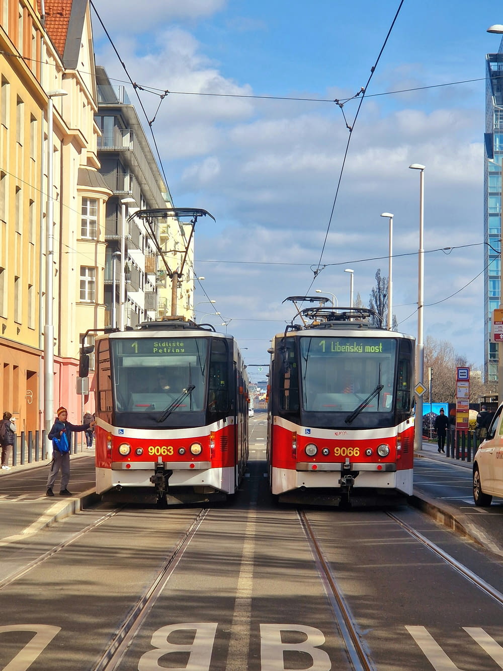 通りを走る赤と白の列車のカップル