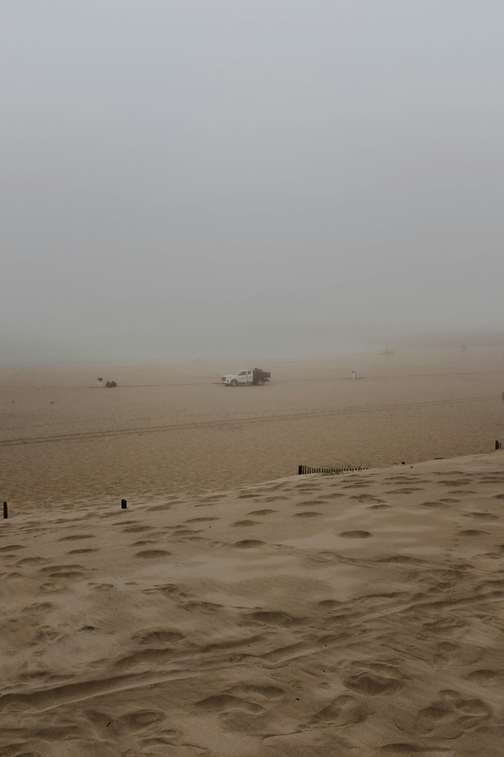 a foggy beach with a boat in the distance