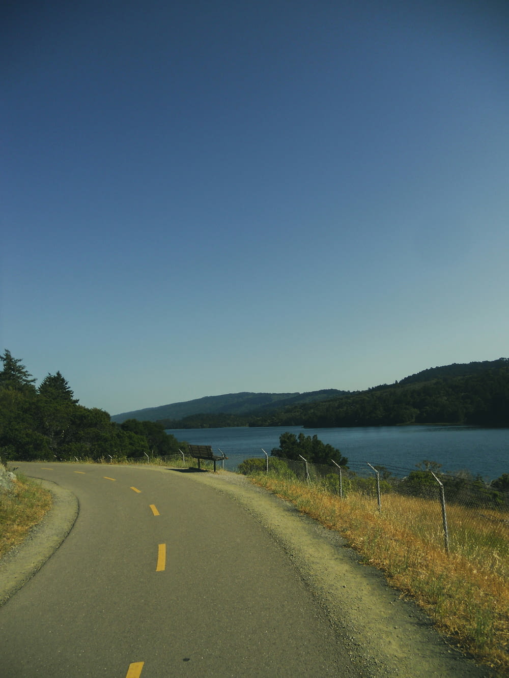 a view of a road next to a body of water
