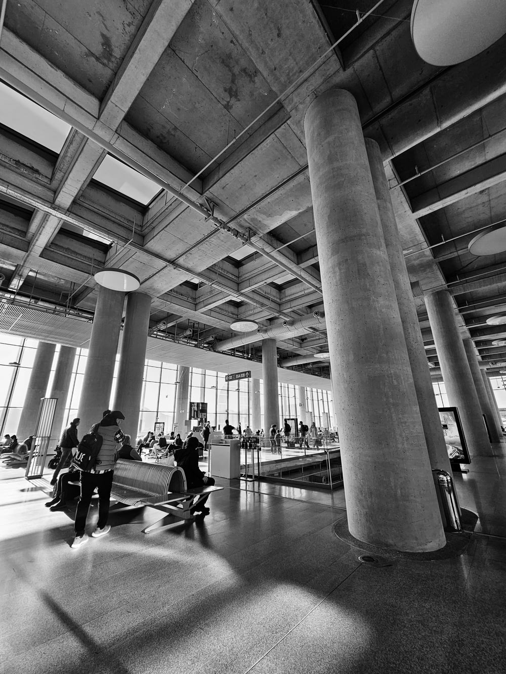 une photo en noir et blanc de personnes assises dans un hall d’entrée