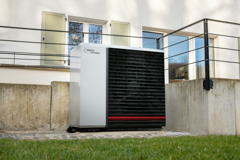 a white air conditioner sitting in front of a building