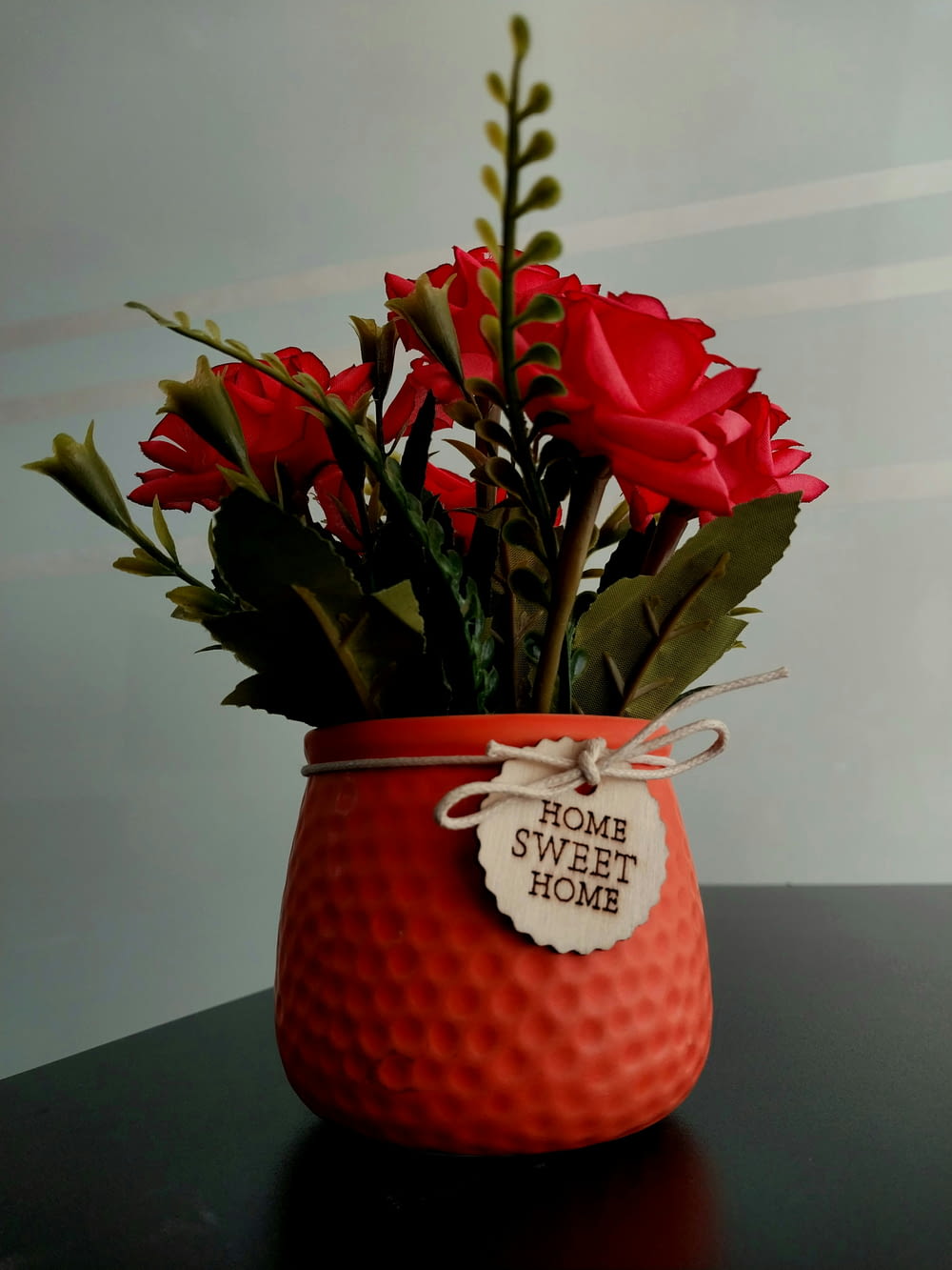 a vase filled with red roses on top of a table
