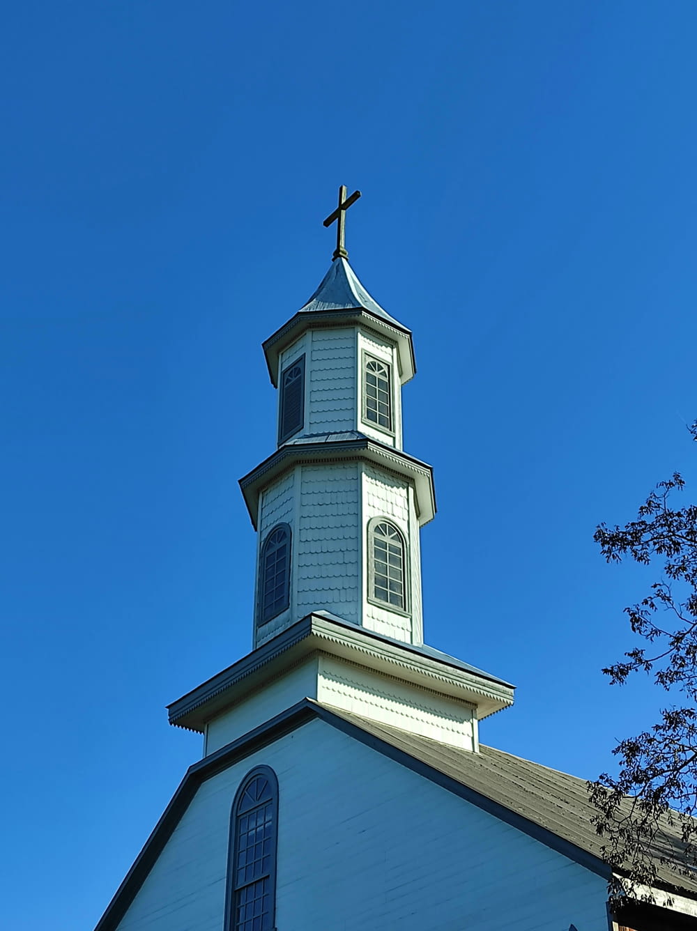 a church steeple with a cross on top