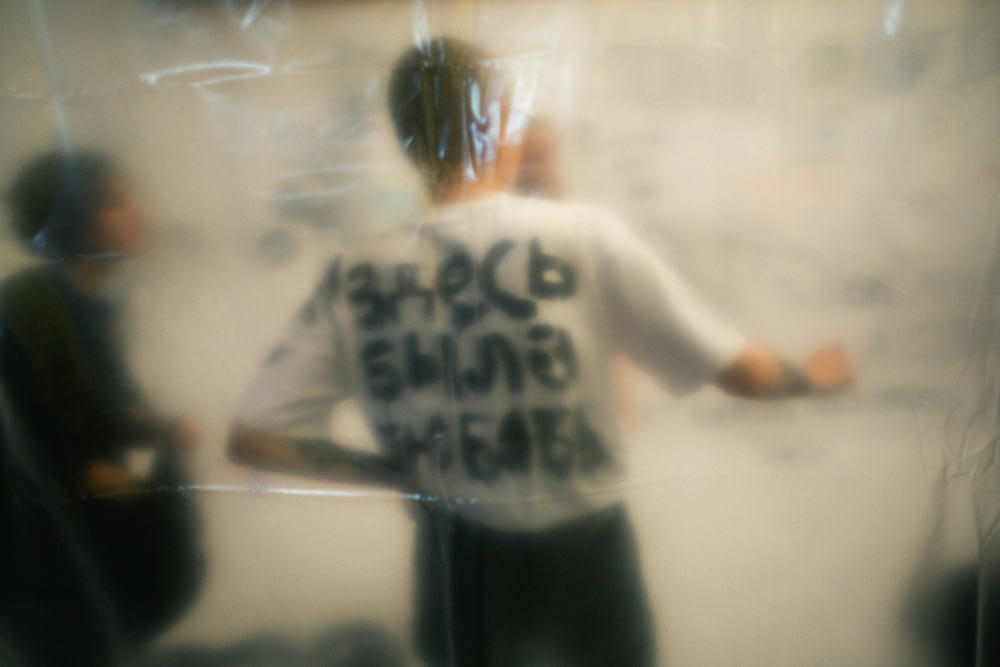 a blurry photo of a man standing in front of a mirror