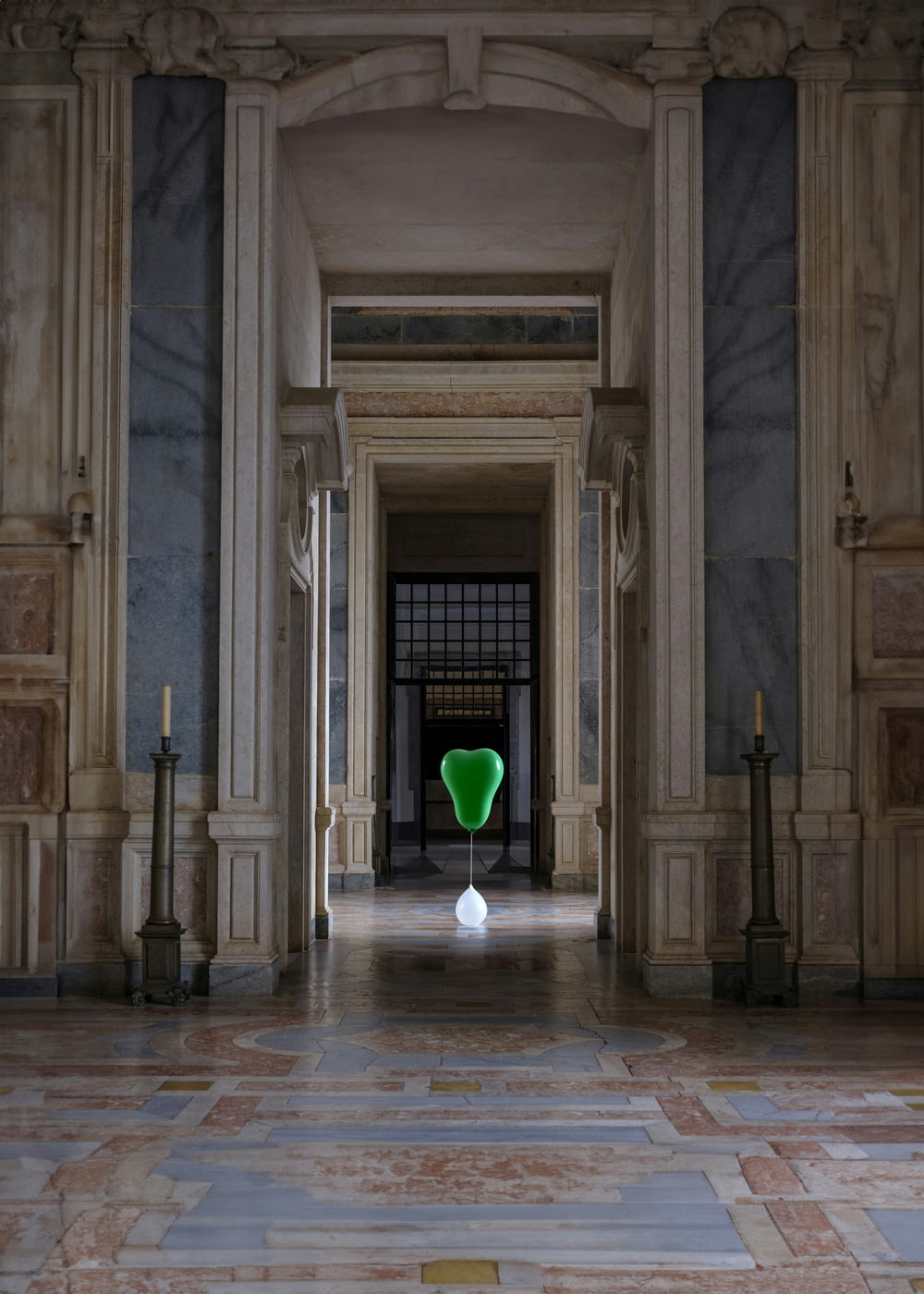 a green vase sitting in the middle of a hallway