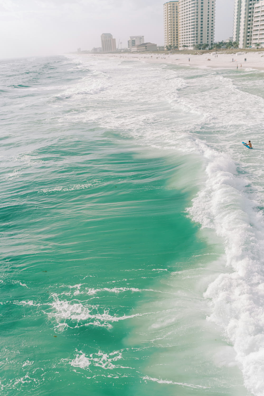 바다의 파도 위에서 서핑 보드를 타는 남자