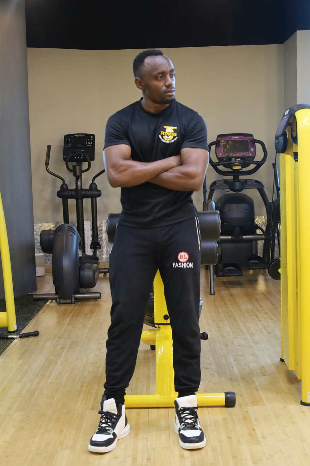 a man standing in a gym with his arms crossed