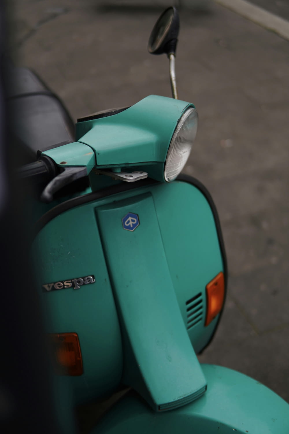 a green scooter parked on the side of the road