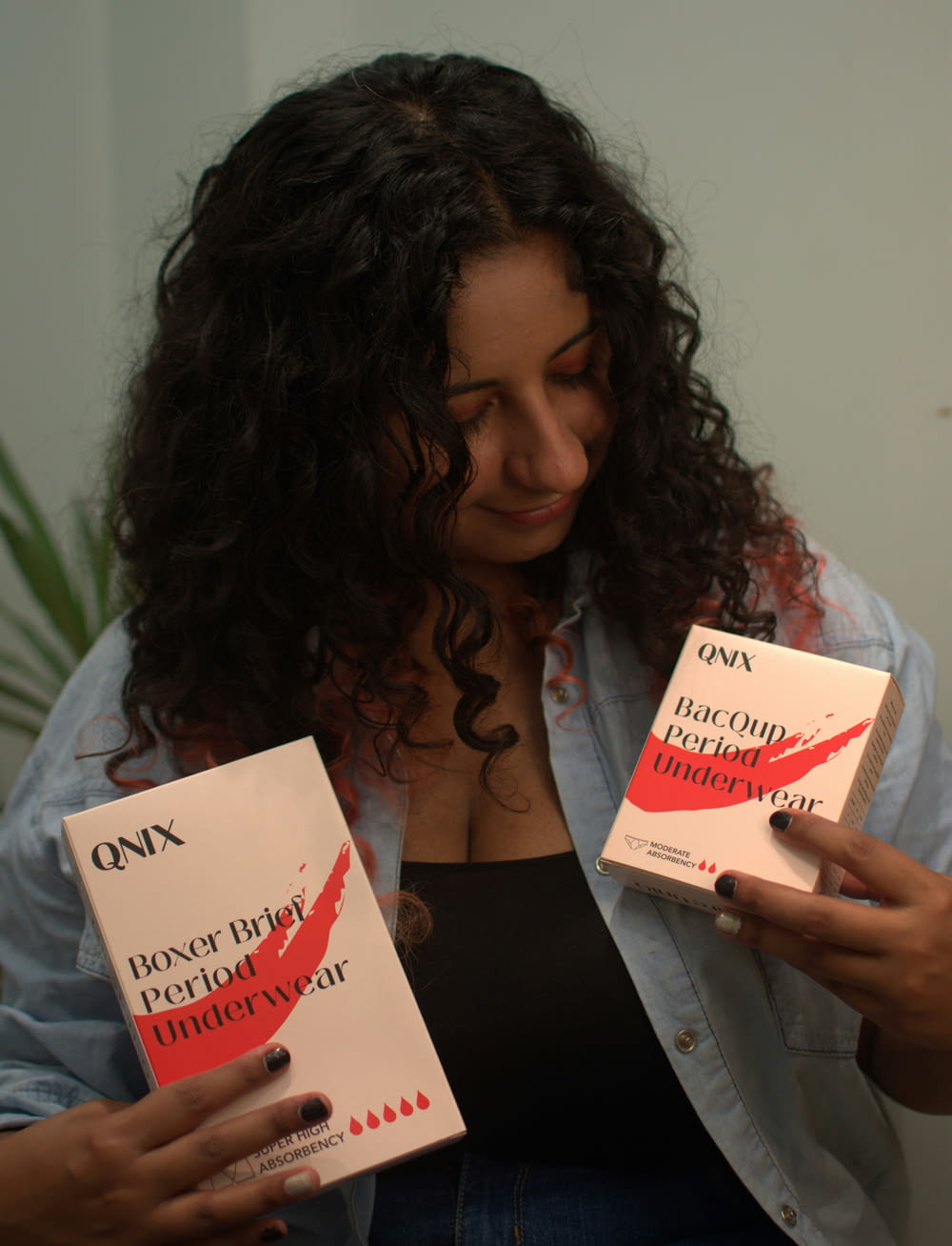 a woman holding two boxes of lipstick