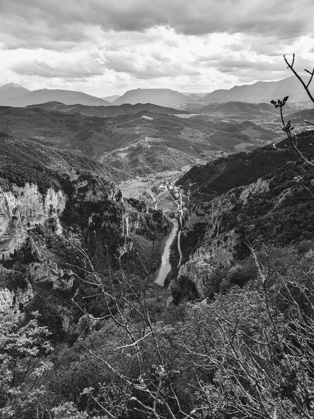 a black and white photo of a waterfall in the mountains