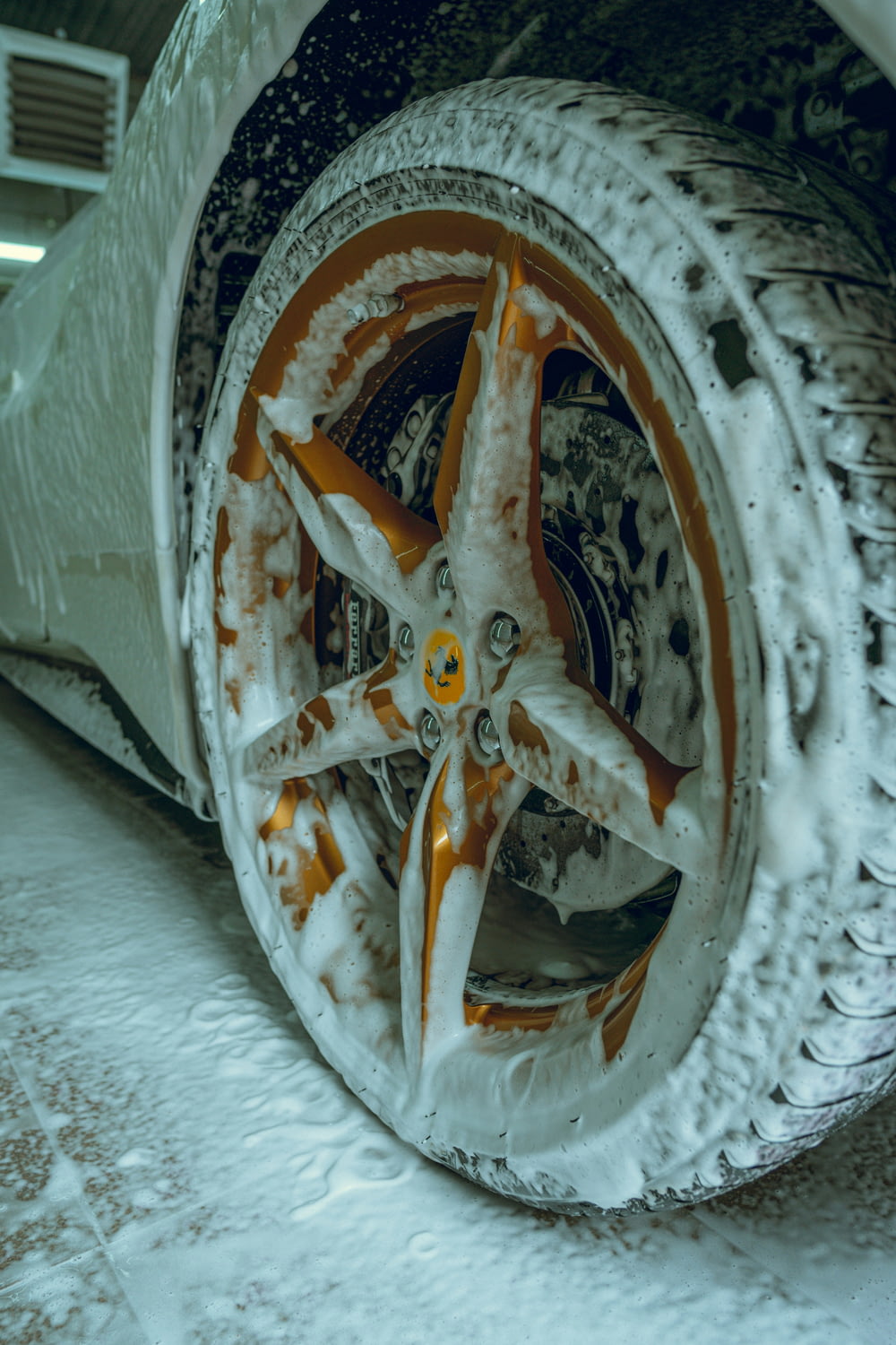 a snow covered car wheel with orange and white paint