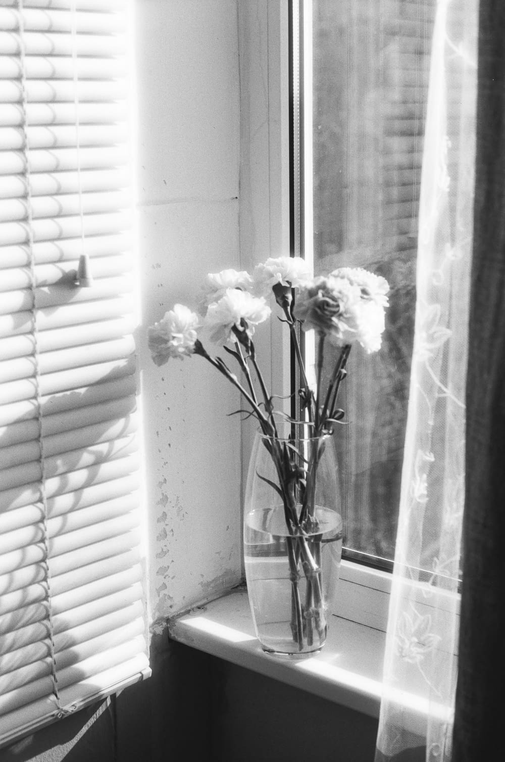 a vase of flowers sitting on a window sill