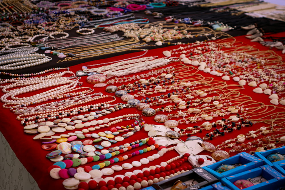 a table topped with lots of different types of necklaces