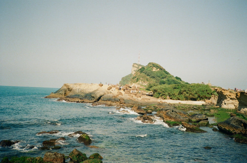 a rocky shore with a small island in the middle of it