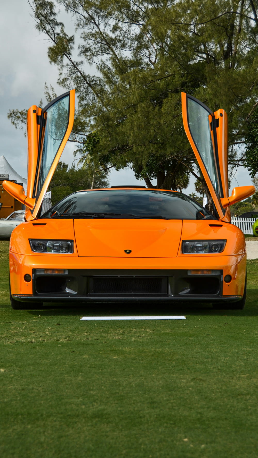 an orange sports car with its doors open