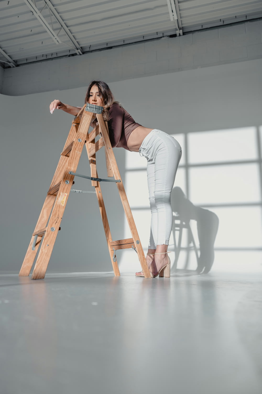 a woman standing on a ladder in a room