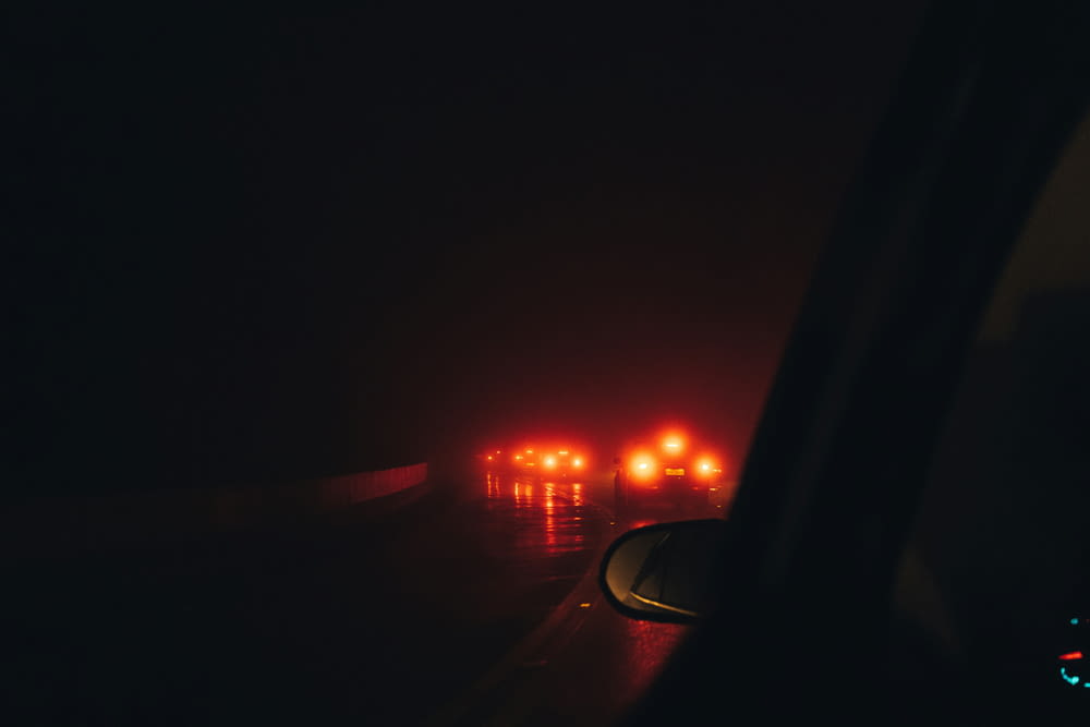 a car driving down a dark road at night