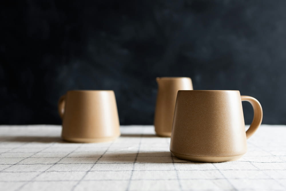 three coffee cups sitting on top of a table