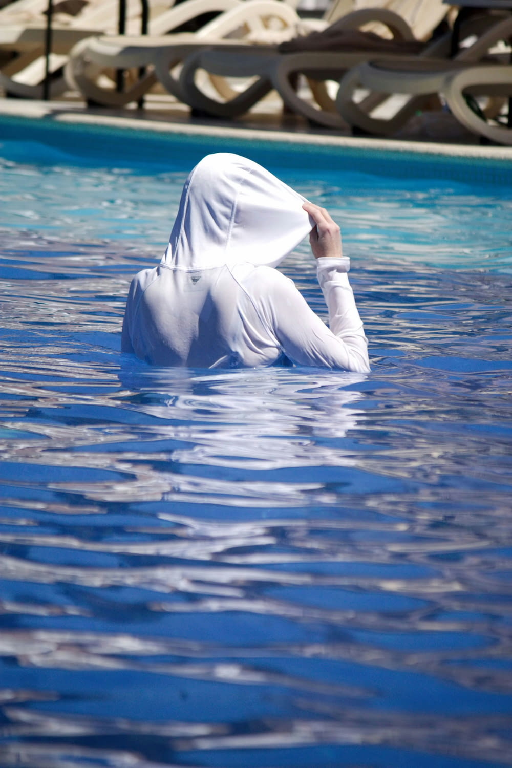 a woman in a white outfit is in a pool