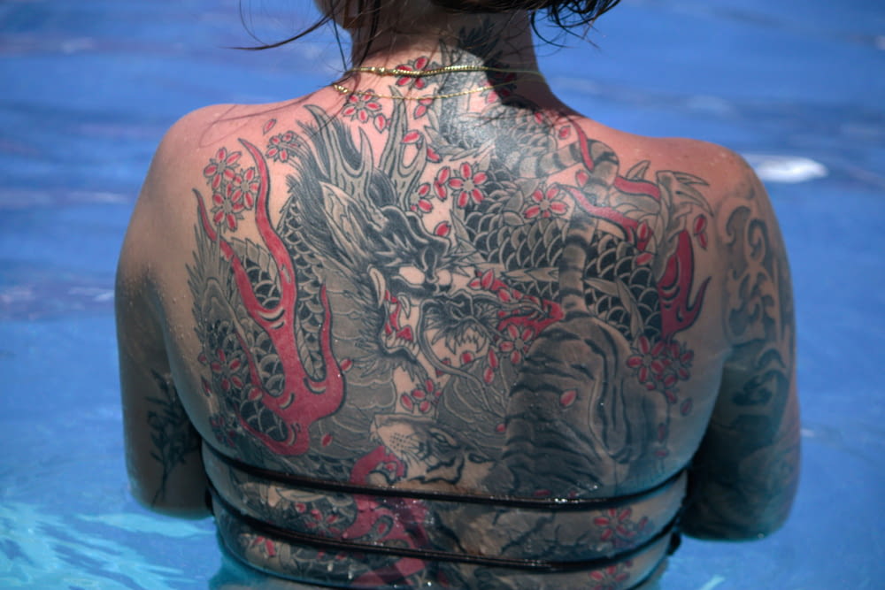 a woman with a dragon tattoo on her back