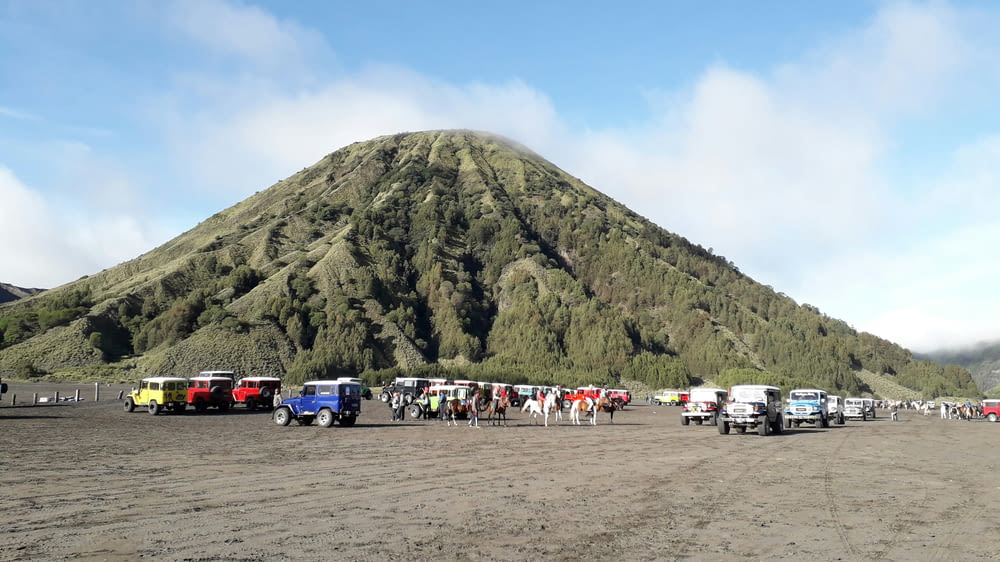 un gruppo di camion parcheggiati di fronte a una montagna