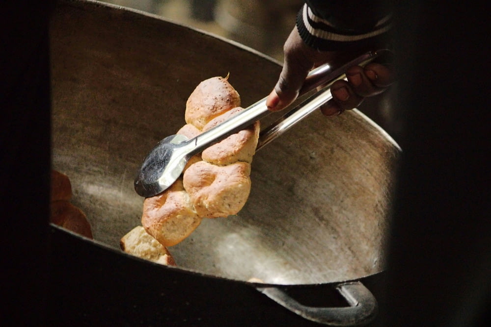 a person scooping some food out of a frying pan