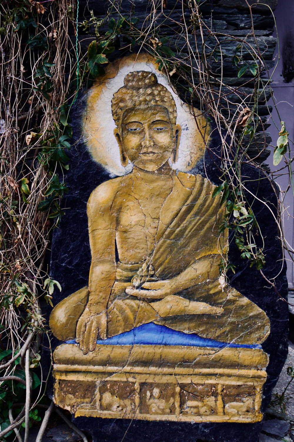 a buddha statue sitting on top of a stone slab
