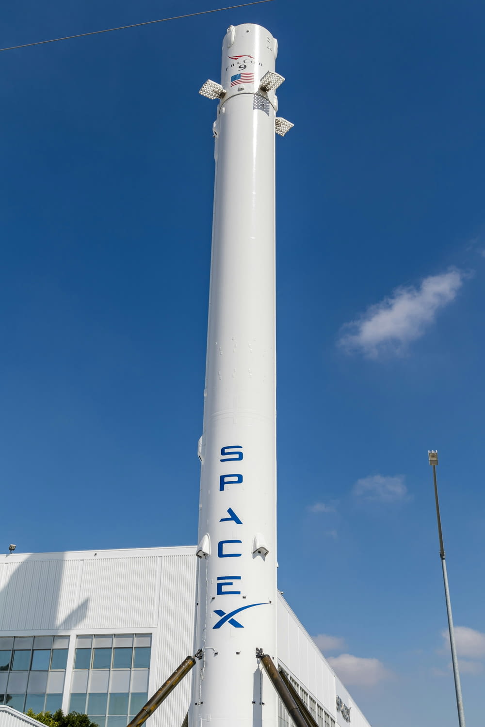 a large white rocket sitting in front of a building
