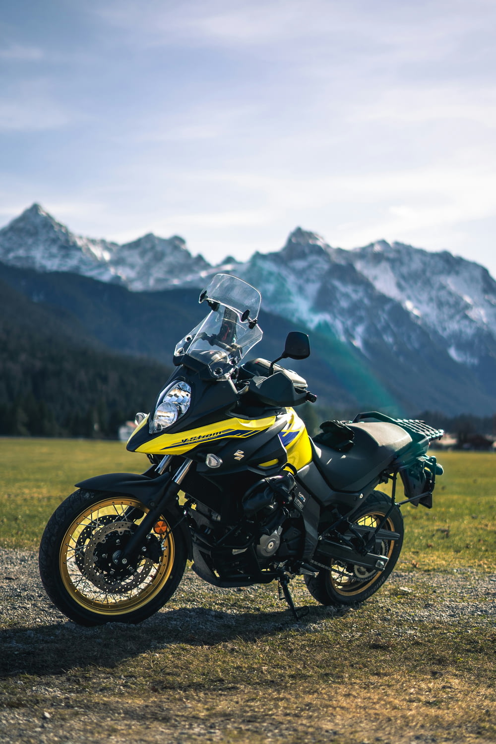 a yellow and black motorcycle parked in a field
