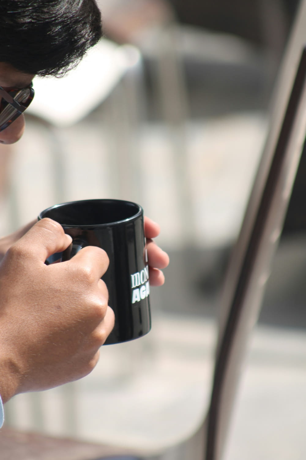 a man holding a black coffee mug in his right hand