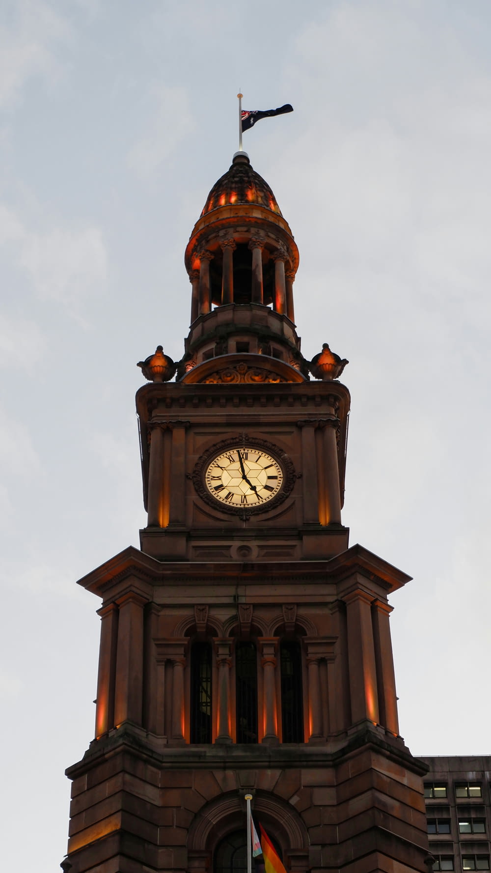 una torre de reloj con una bandera en la parte superior
