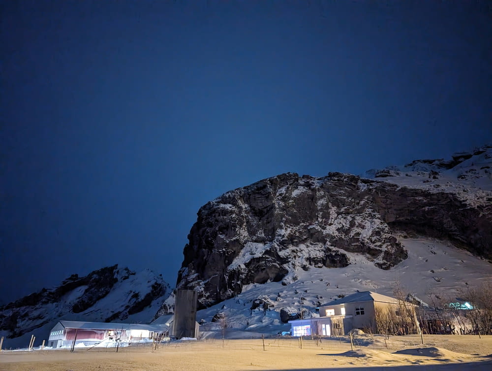 a snow covered mountain at night with a sky background