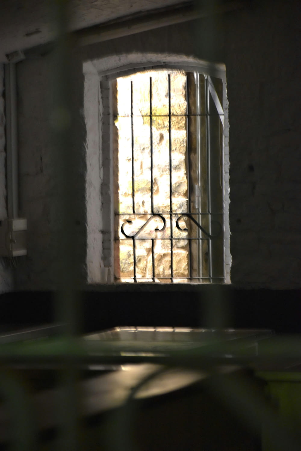 a jail cell with bars and a window