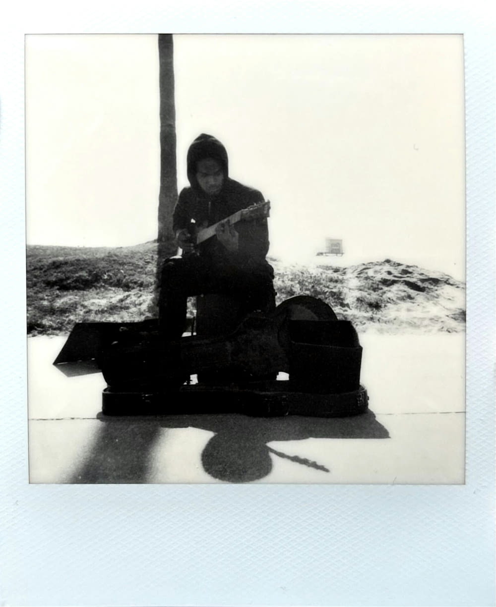 a woman sitting on a suitcase on the beach