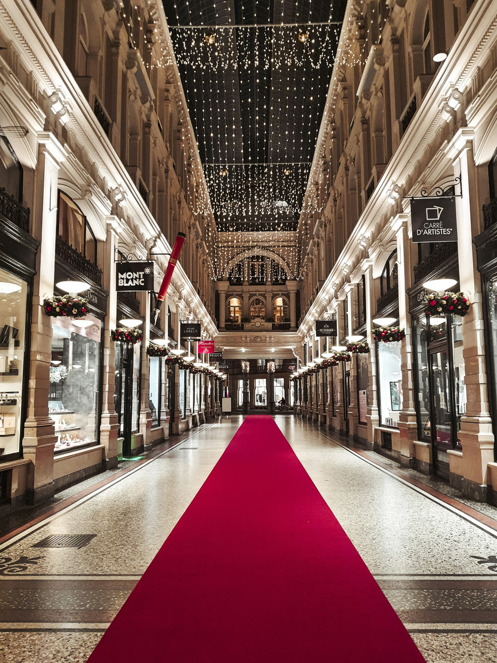 a red carpet is on the floor of a shopping mall