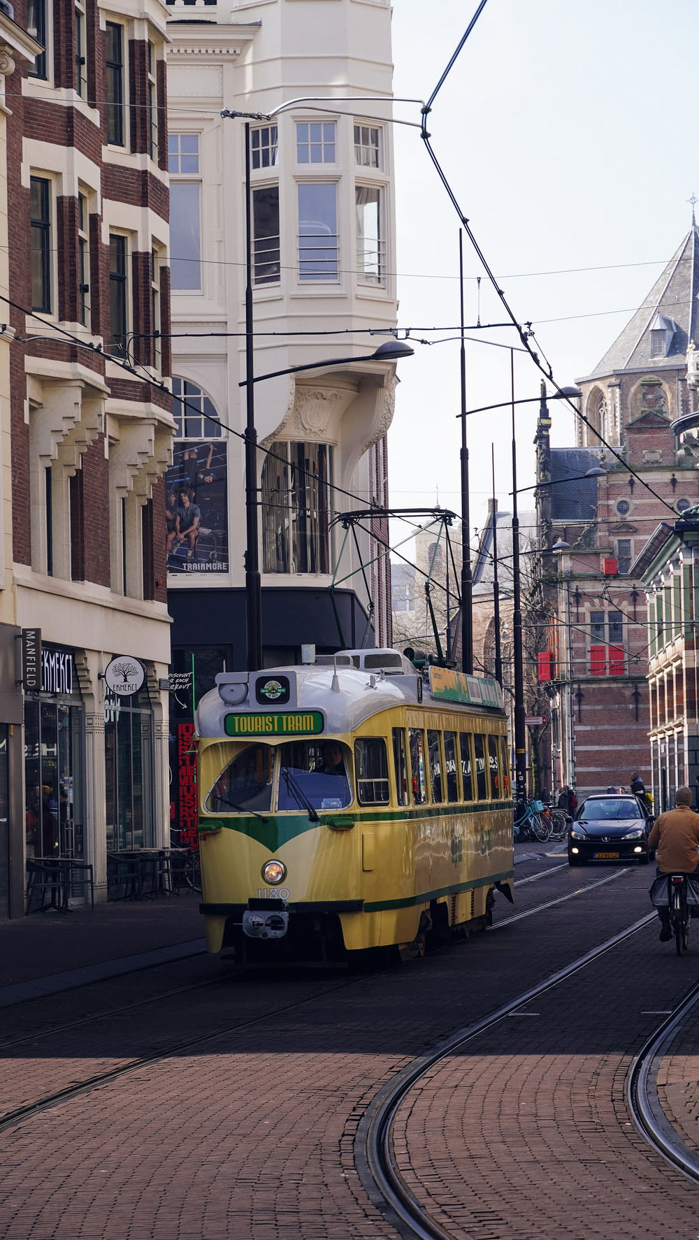 a yellow and green trolley on a city street